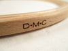 Wooden ring with 'D.M.C.' engraving on a light fabric background