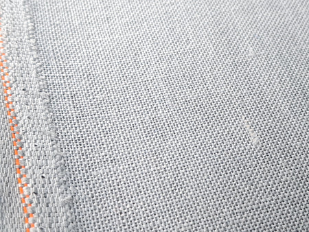 Close-up of gray fabric with orange stitching detail