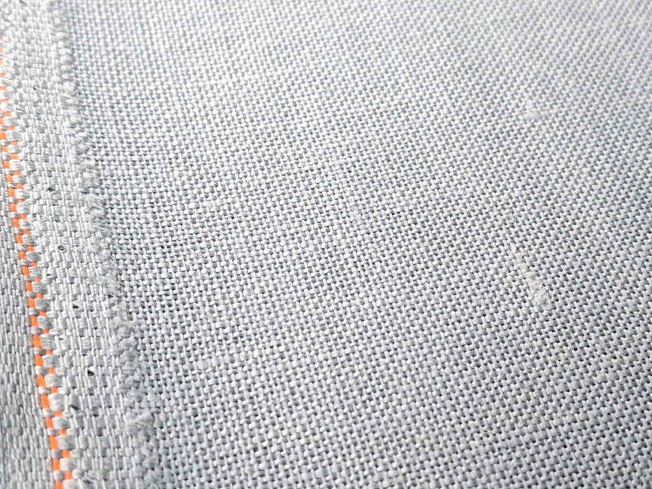 Close-up of gray fabric with orange stitching detail